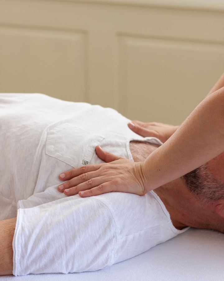 Shiatsu-Anwendung: Hände liegen sanft auf dem Brustkorb eines liegenden Klienten
